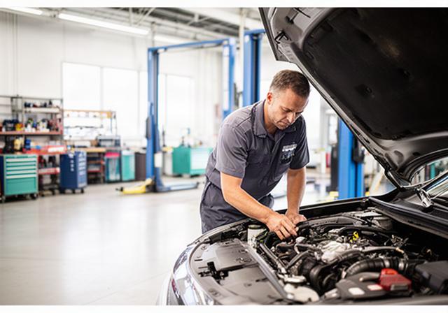 Mechanic inspecting an engine bay in a bright Winnipeg auto repair shop